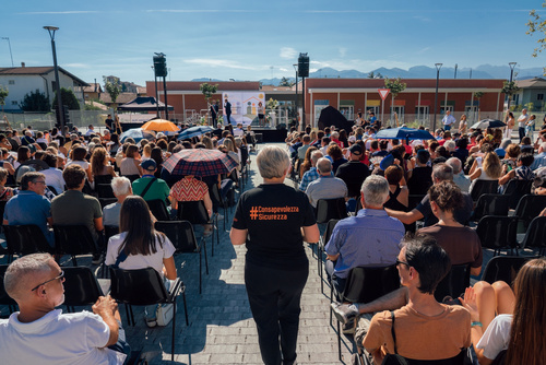 Il pubblico in piazza — inaugurazione Polo per l'Infanzia Piero Angela Il pubblico in piazza durante i discorsi di inaugurazione, sullo sfondo il nuovo edificio e le montagne