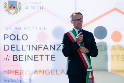 Il sindaco Lorenzo Busciglio — inaugurazione 6 settembre 2026 Il sindaco Lorenzo Busciglio al microfono davanti alla locandina dell'inaugurazione del Polo per l'Infanzia Piero Angela, 6 settembre 2026